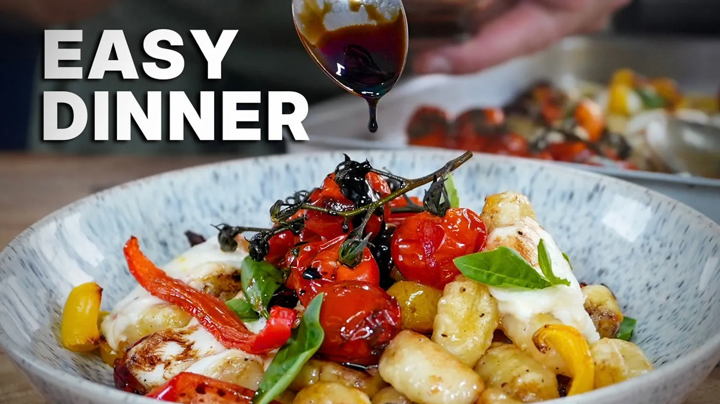 Bowl of gnocchi with colorful roasted veggies and basil, drizzled with sauce. Text reads "EASY DINNER" in bold. Cozy kitchen setting.