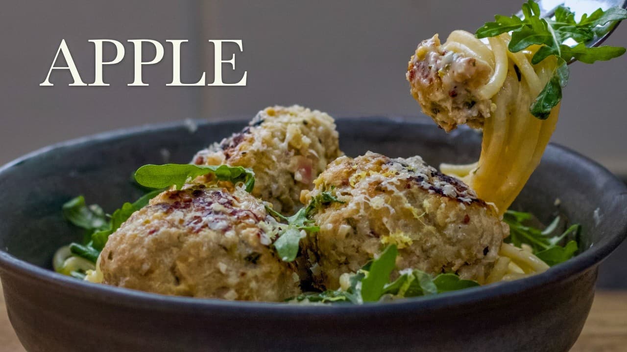 Pork and apple meatballs in creamy cider sauce, a still from its video, with the channel name and the recipe title in text across it