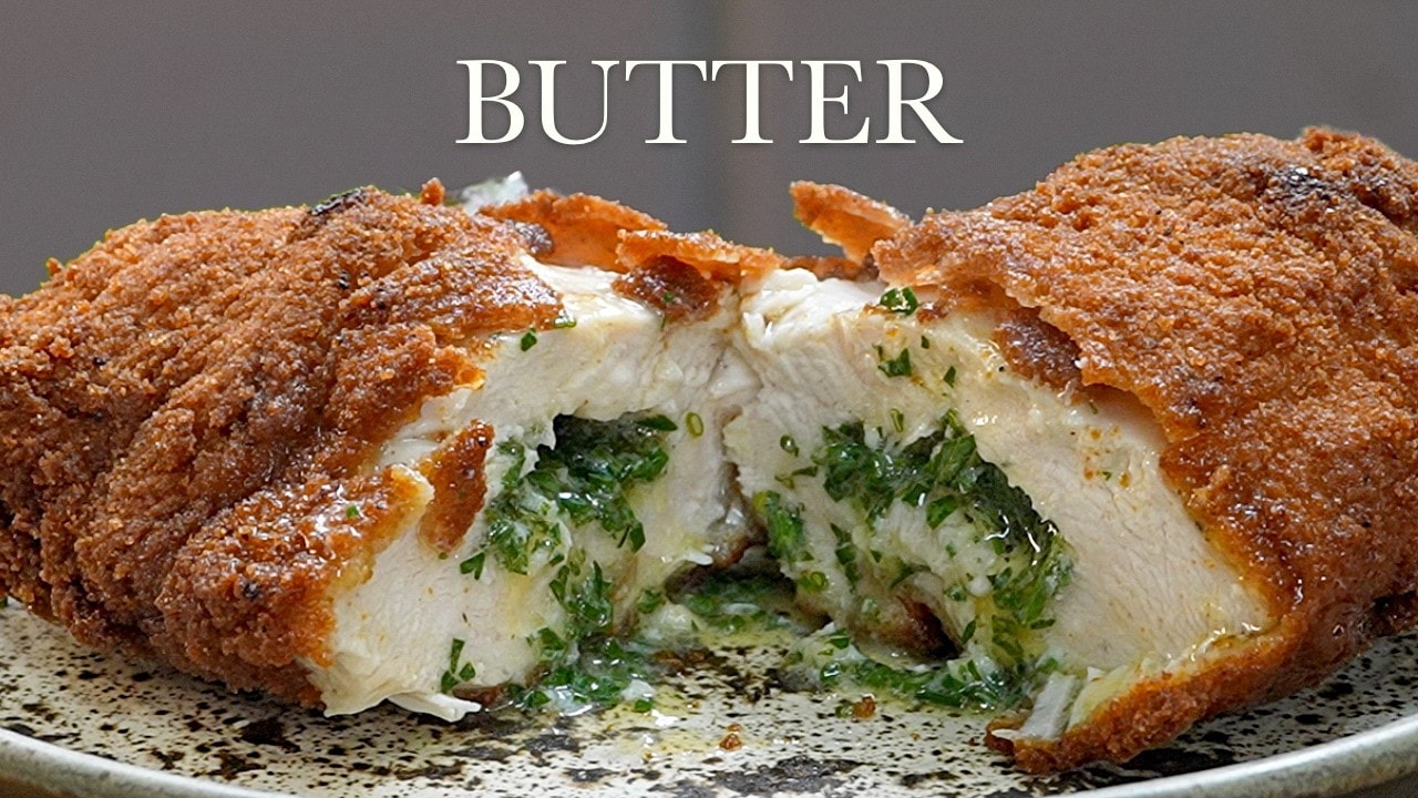 Chicken Kiev with garlic butter, a still from its video, with the channel name and the recipe title in text across it